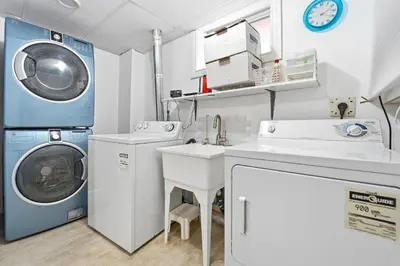a laundry room with a washing machine and a sink at Tranquil Bliss Retreat 9 min to Falls with Free Parking in Niagara Falls