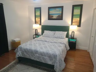 a bedroom with a bed and two lamps on two tables at The Taunton House in Ajax