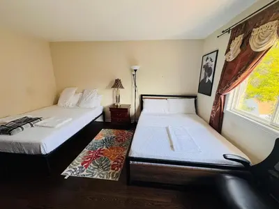 a room with two beds and a window at Scarborough Spacious Private Suite 2 Queen Beds & Ensuite in Toronto