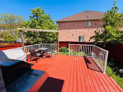 a wooden deck with a table and chairs on it at Scarborough Spacious Private Suite 2 Queen Beds & Ensuite in Toronto