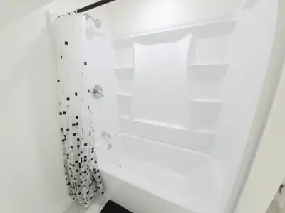 a white shower with a black and white shower curtain at Niagara Cozy Suite - Modern 2Bed 15 min to Falls in Thorold