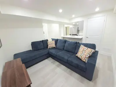 a blue couch in a living room with a table at Niagara Cozy Suite - Modern 2Bed 15 min to Falls in Thorold