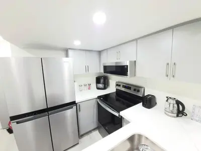 a kitchen with white cabinets and a stainless steel refrigerator at Niagara Cozy Suite - Modern 2Bed 15 min to Falls in Thorold