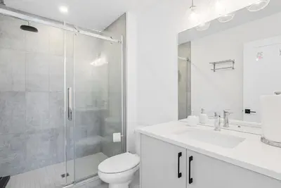 a bathroom with a shower and a toilet and a sink at Modern 3BR House, King, 2 Queens, Parking in London