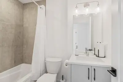 a white bathroom with a toilet and a sink at Modern 3BR House, King, 2 Queens, Parking in London