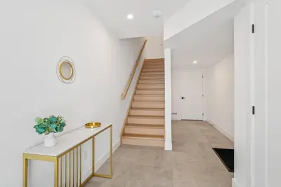 a hallway with white walls and stairs with a stair case at Modern 3BR House, King, 2 Queens, Parking in London