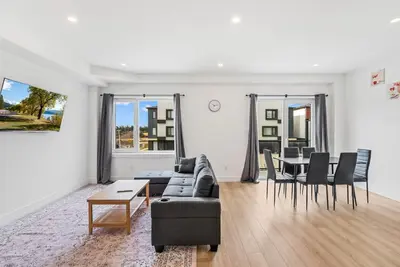 a living room with a couch and a table at Modern 3BR House, King, 2 Queens, Parking in London