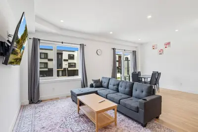 a living room with a couch and a table at Modern 3BR House, King, 2 Queens, Parking in London