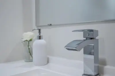 a bathroom sink with a faucet and a bottle of soap at Newly Renovated 2BR Basement Suite, Private Entry in Pickering