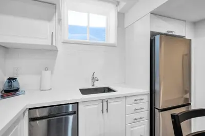 a white kitchen with a sink and a refrigerator at Newly Renovated 2BR Basement Suite, Private Entry in Pickering