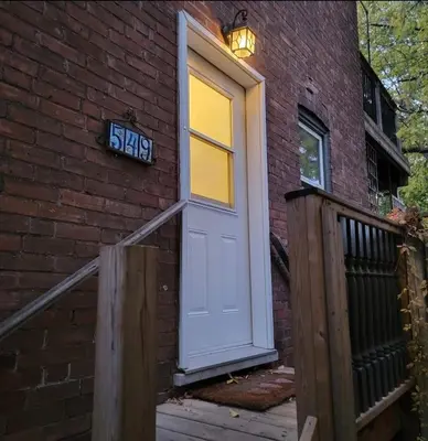 a white door on the side of a brick building at 1 Bedroom basement Suite in Junction Bloor West Village in Toronto