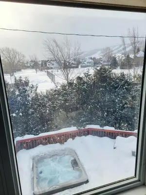 a hot tub in the snow outside a window at Private Ski Chalet Hot Tub & Mountain Views in Blue Mountains