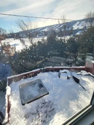 a snow covered yard with a hot tub on a roof at Private Ski Chalet Hot Tub & Mountain Views in Blue Mountains