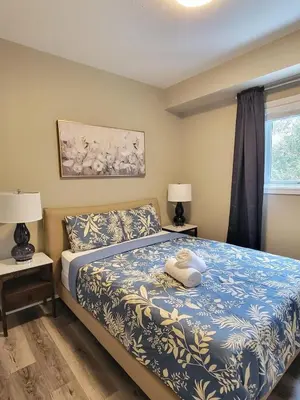 a bedroom with a bed and two lamps and a window at Private Ski Chalet Hot Tub & Mountain Views in Blue Mountains