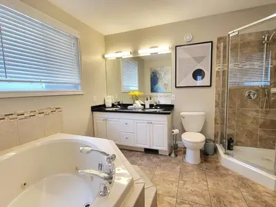 a bathroom with a tub and a toilet and a sink at Private Ski Chalet Hot Tub & Mountain Views in Blue Mountains