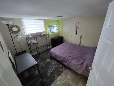 a bedroom with a purple bed and a window at Bright Room in Walkout Basement in Pickering