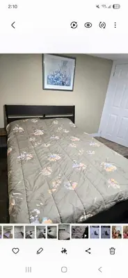 a bed with a comforter with flowers on it at Bright Room in Walkout Basement in Pickering