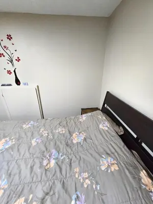 a bedroom with a bed with flowers on it at Bright Room in Walkout Basement in Pickering