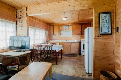 a kitchen with a table and a refrigerator at Charming Lakeview Family Resort in Katchwanooka with Private BBQ and firepit in Lakefield