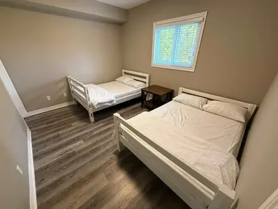a bedroom with two beds and a window at 5 Bedrooms, Mountain Views, Steps from Blue Mountain Village, Hot Tub, BBQ in Blue Mountains
