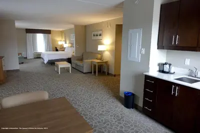 a hotel room with a bed and a living room at Holiday Inn Express & Suites Oshawa Downtown - Toronto Area by IHG in Oshawa