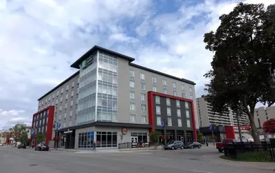 a building on a street with cars parked in front of it at Holiday Inn Express & Suites Oshawa Downtown - Toronto Area by IHG in Oshawa