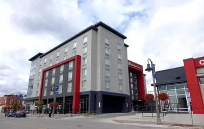 a white and red building on a city street at Holiday Inn Express & Suites Oshawa Downtown - Toronto Area by IHG in Oshawa