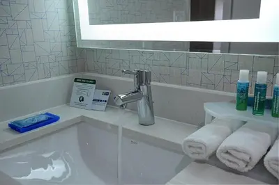 a bathroom with a tub and a sink with towels at Holiday Inn Express & Suites Toronto Airport West by IHG in Mississauga