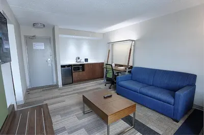 a living room with a blue couch and a table at Holiday Inn Express & Suites Toronto Airport West by IHG in Mississauga