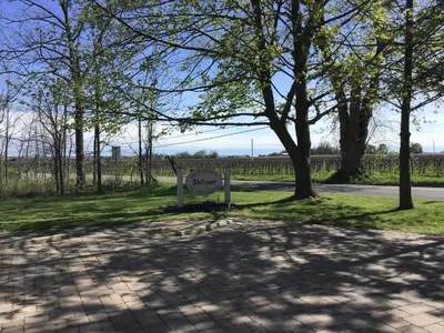 a sign sitting in the grass next to a road at Old Town Country Landing in Niagara on the Lake