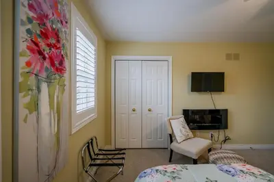 a room with a bed and a vase with flowers at Old Town Country Landing in Niagara on the Lake