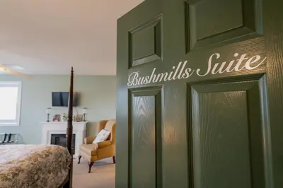a bedroom with a green door with a living room at Old Town Country Landing in Niagara on the Lake