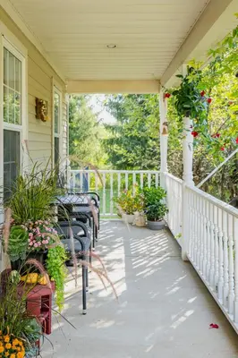 a porch with tables and chairs and flowers at Old Town Country Landing in Niagara on the Lake