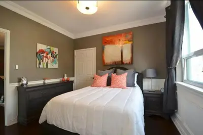 a bedroom with a large bed with pink pillows at The SoMa Furnished Residences in Hamilton