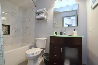 a bathroom with a toilet and a sink and a mirror at The SoMa Furnished Residences in Hamilton