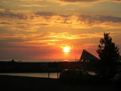 a sunset over a body of water with a building at Royal Harbour Resort in Thornbury