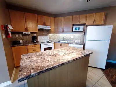 a kitchen with wooden cabinets and a marble counter top at Royal Harbour Resort in Thornbury