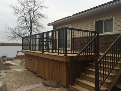 a deck with a black railing on a house at Victoria Harbour Cottages in Victoria Harbour