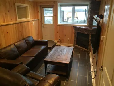 a living room with a leather couch and a coffee table at Victoria Harbour Cottages in Victoria Harbour