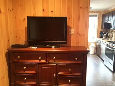 a television on top of a wooden dresser in a kitchen at Victoria Harbour Cottages in Victoria Harbour