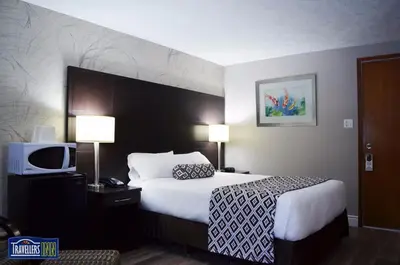 a hotel room with a bed and a tv at Travellers Inn in Hanover