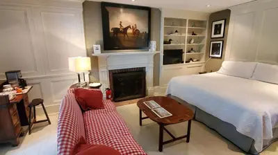 a bedroom with a bed and a fireplace at Dot's Landing Garden Room in Niagara on the Lake