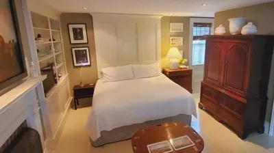 a bedroom with a large bed with a white bedspread at Dot's Landing Garden Room in Niagara on the Lake