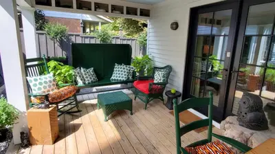 a patio with chairs and a bench on a porch at Dot's Landing Garden Room in Niagara on the Lake