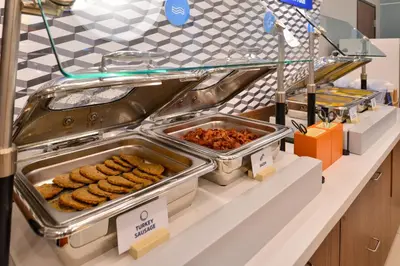 a buffet line with trays of food on a counter at Holiday Inn Express & Suites Vaughan-Southwest by IHG in Vaughan