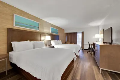 a hotel room with two beds and a flat screen tv at Holiday Inn Hotel Peterborough Waterfront by IHG in Peterborough