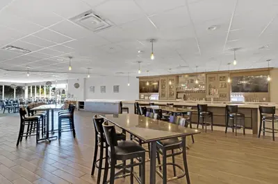 a restaurant with tables and chairs and a bar at Holiday Inn Hotel Peterborough Waterfront by IHG in Peterborough