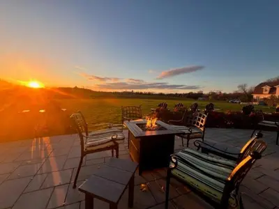 a sunset on a patio with chairs and a table at Riverbend Inn & Vineyard in Niagara on the Lake