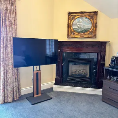 a living room with a fireplace and a flat screen tv at Riverbend Inn & Vineyard in Niagara on the Lake