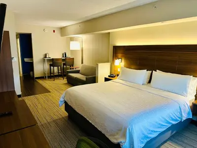 a hotel room with a large bed and a chair at Holiday Inn Express Hotel & Suites Milton by IHG in Milton